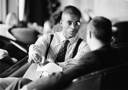 Businessmen sitting, discussing document, b&w. Stock Photo - Premium Royalty-Free, Code: 632-01138238