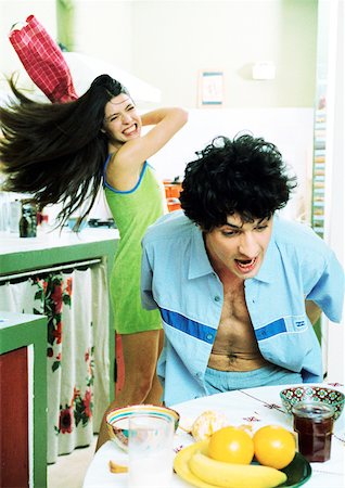 furore valley - Man at breakfast table, woman swinging kitchen towel at man. Foto de stock - Royalty Free Premium, Número: 632-01144112