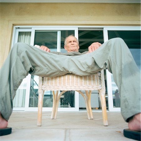 Senior man sitting with legs spread, low angle view Stock Photo - Premium Royalty-Free, Code: 632-01144278