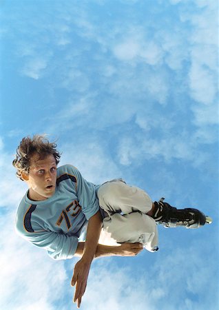 skate stunts - Young man on rollerblades, jumping, mid-air, low angle. Stock Photo - Premium Royalty-Free, Code: 632-01144716