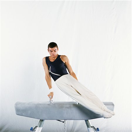 simsearch:632-01145022,k - Male gymnast performing routine on pommel horse Foto de stock - Sin royalties Premium, Código: 632-01144994