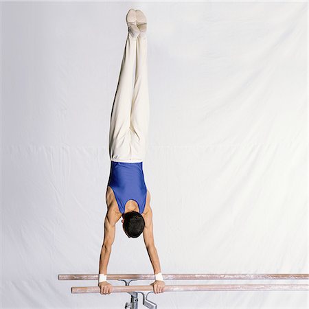 Young male gymnast performing routine on parallel bars, rear view Stock Photo - Premium Royalty-Free, Code: 632-01144990