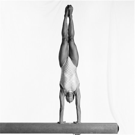 Young female gymnast performing handstand on balance beam Stock Photo - Premium Royalty-Free, Code: 632-01145008