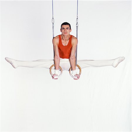 Male gymnast performing on rings, looking at camera Foto de stock - Sin royalties Premium, Código: 632-01145024