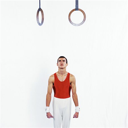 Gymnaste masculin debout sous les anneaux, en levant Photographie de stock - Premium Libres de Droits, Code: 632-01145034