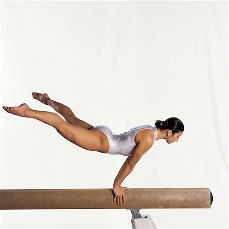 Young female gymnast performing routine on balance beam, side view Stock Photo - Premium Royalty-Free, Code: 632-01145030