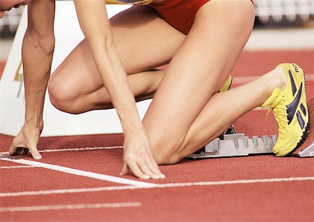 starting block kneeling race track - Female runner on starting block, low section, close-up Stock Photo - Premium Royalty-Free, Code: 632-01145128