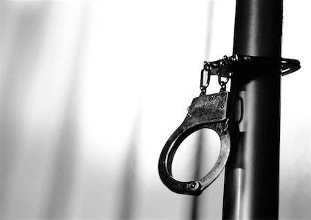 Handcuffs attached to pipe, b&w. Stock Photo - Premium Royalty-Free, Code: 632-01145295