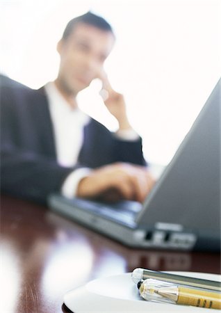 Businessman using laptop computer, blurred Stock Photo - Premium Royalty-Free, Code: 632-01146007