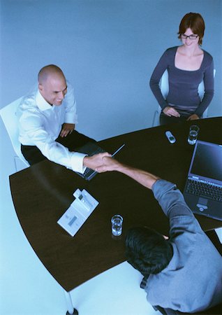 simsearch:632-03779792,k - Businesspeople sitting at desk, two men shaking hands, elevated view Stock Photo - Premium Royalty-Free, Code: 632-01146067