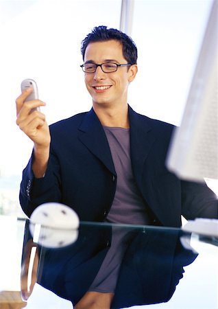 Businessman holding cell phone, smiling Stock Photo - Premium Royalty-Free, Code: 632-01146148