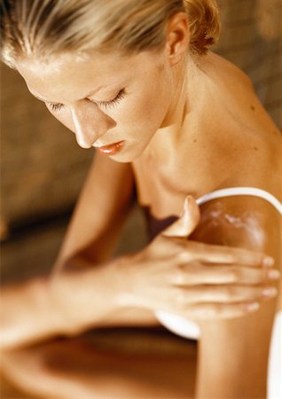 Woman putting lotion on shoulder, high angle view Stock Photo - Premium Royalty-Free, Code: 632-01146593