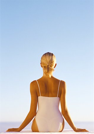 ponytail sunbathing - Woman in one-piece bathing suit, hands out to the side, waist up, rear view, blue sky in background Stock Photo - Premium Royalty-Free, Code: 632-01146613
