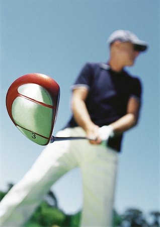 simsearch:632-01146688,k - Mature man holding golf club, low angle view, blurred Foto de stock - Sin royalties Premium, Código: 632-01146661