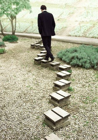 path wide angle - Man walking on stepping stones, rear view Stock Photo - Premium Royalty-Free, Code: 632-01147082