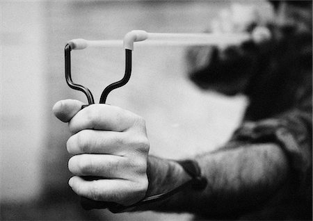 regression - Hands holding sling shot, close-up, b&w Stock Photo - Premium Royalty-Free, Code: 632-01147312