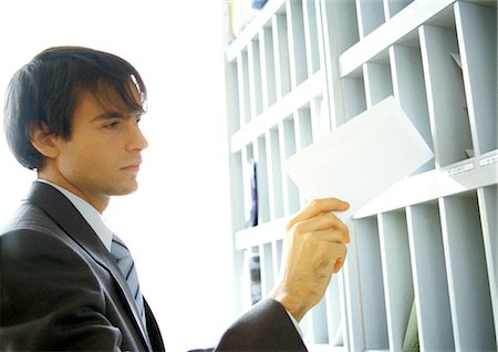 Businessman pulling mail out of slot Foto de stock - Sin royalties Premium, Código: 632-01147817