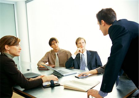 Business people looking at businessman standing Stock Photo - Premium Royalty-Free, Code: 632-01147838