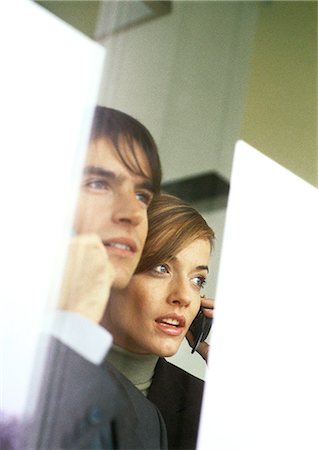 Businessman and businesswoman talking on cell phones, partial view, head and shoulders Foto de stock - Sin royalties Premium, Código: 632-01147868