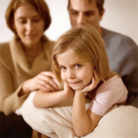 simsearch:632-01147960,k - Little girl looking at camera, parents behind her Stock Photo - Premium Royalty-Free, Code: 632-01147951