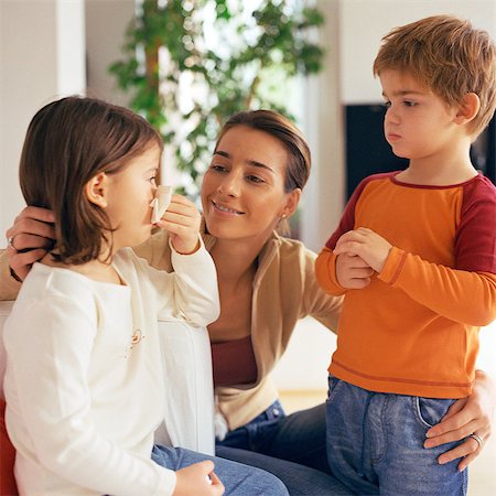 rivalidade entre irmãos - Woman with arms around two children, looking at girl blowing nose Foto de stock - Royalty Free Premium, Número: 632-01147960