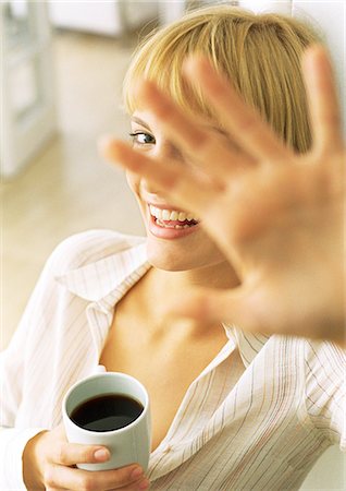 pov coffee cup - Teen girl with coffee holding hand in front of face, laughing Stock Photo - Premium Royalty-Free, Code: 632-01148147