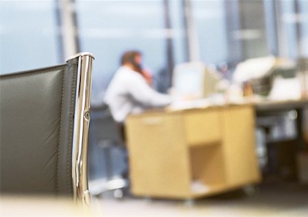 Businessman sitting at desk talking on phone, blurred. Stock Photo - Premium Royalty-Free, Code: 632-01148394