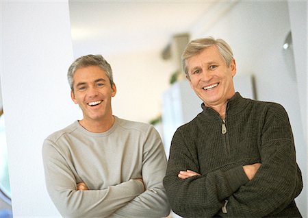 Men standing next to each other crossing arms, laughing, portrait Stock Photo - Premium Royalty-Free, Code: 632-01148404