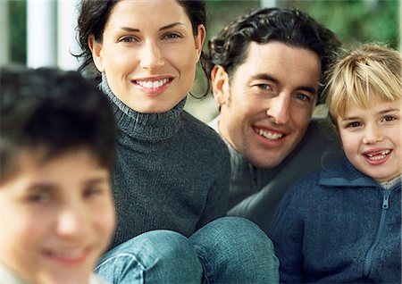 simsearch:632-02345201,k - Adult man and woman with girl, smiling, in background, boy blurred in foreground Foto de stock - Royalty Free Premium, Número: 632-01148475