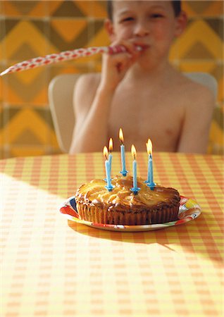 Little boy with birthday cake and party horn blower Stock Photo - Premium Royalty-Free, Code: 632-01148740