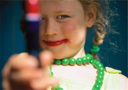 pic lipstick girls - Little girl playing dress-up, holding out tube of lipstick Stock Photo - Premium Royalty-Free, Code: 632-01148752