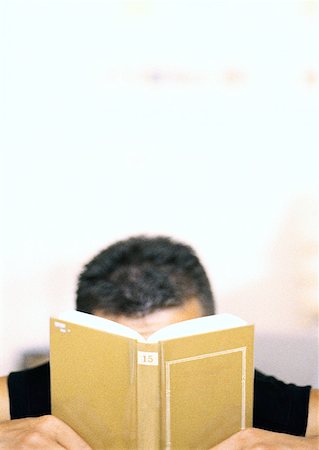 simsearch:632-05553628,k - Man holding book in front of face Stock Photo - Premium Royalty-Free, Code: 632-01149053