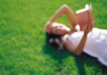 simsearch:632-05400916,k - Woman lying on grass, reading, defocused Foto de stock - Royalty Free Premium, Número: 632-01149082