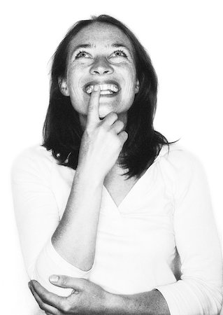 Woman smiling, finger on mouth, portrait, b&w. Stock Photo - Premium Royalty-Free, Code: 632-01149142