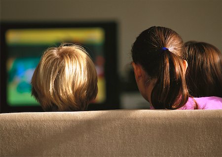 Young boys and girl sitting on couch watching TV, rear view Stock Photo - Premium Royalty-Free, Code: 632-01149457