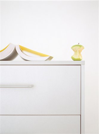 Open book and apple core on top of dresser Stock Photo - Premium Royalty-Free, Code: 632-01149485