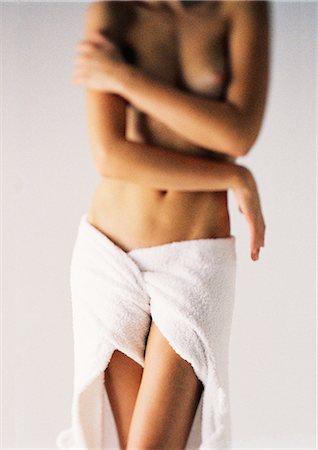 Woman standing with towel wrapped around waist, arms folded across chest, mid section, front view Foto de stock - Sin royalties Premium, Código: 632-01149975
