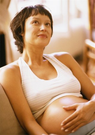short haired women pregnant - Pregnant woman in armchair, hand on belly and looking up Stock Photo - Premium Royalty-Free, Code: 632-01140034