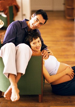 diffuse - Man sitting backwards on chair and pregnant woman sitting on floor, leaning head on man, portrait Stock Photo - Premium Royalty-Free, Code: 632-01140078
