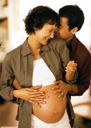 simsearch:632-01140071,k - Man touching pregnant woman's stomach from behind Foto de stock - Sin royalties Premium, Código: 632-01140070