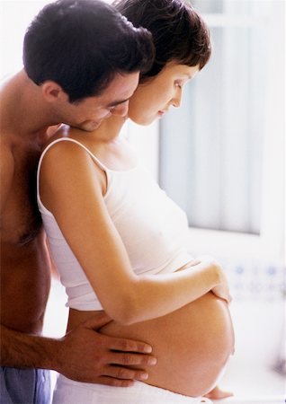 simsearch:633-05401926,k - Taille de la femme enceinte de rétention de l'homme et regarder par-dessus son épaule, côté vue Photographie de stock - Premium Libres de Droits, Code: 632-01140088