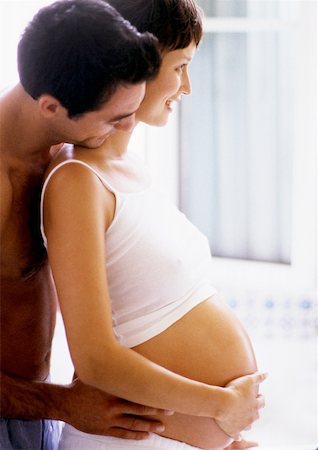 simsearch:633-05401926,k - Taille de la femme enceinte de rétention de l'homme et regarder par-dessus son épaule, côté vue Photographie de stock - Premium Libres de Droits, Code: 632-01140089