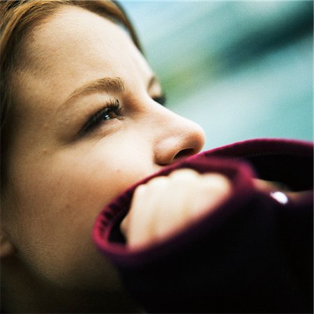 Young woman with hands over mouth, side view, close-up Stock Photo - Premium Royalty-Free, Code: 632-01141147