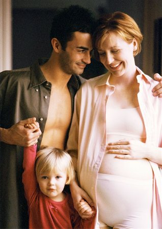 simsearch:695-03384752,k - Pregnant woman and man standing with child, smiling, portrait Foto de stock - Royalty Free Premium, Número: 632-01141192