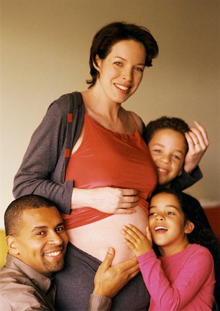 simsearch:695-03384752,k - Man and children around pregnant woman's exposed stomach Foto de stock - Royalty Free Premium, Número: 632-01141238