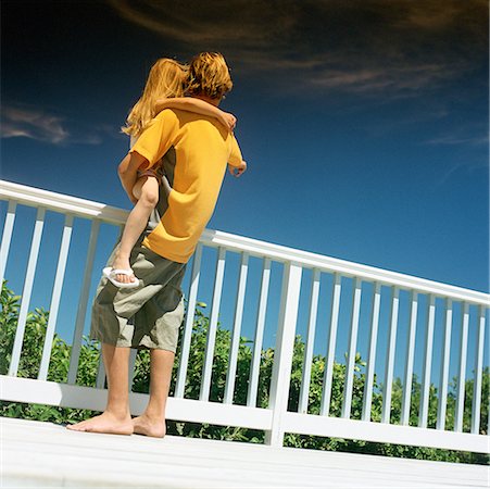 family in balcony - Boy holding little girl next to railing, rear view Stock Photo - Premium Royalty-Free, Code: 632-01142783