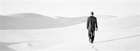 simsearch:400-04034980,k - Businessman walking across dunes, rear view, b&w, panoramic view Foto de stock - Royalty Free Premium, Número: 632-01143353