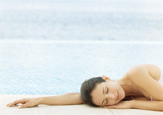 Woman napping on ground at edge of water Stock Photo - Premium Royalty-Free, Image code: 632-01154185