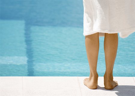 Woman wearing bathrobe standing by side of pool, rear view of legs Stock Photo - Premium Royalty-Free, Code: 632-01154229