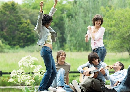 simsearch:695-03382465,k - Group of friends outdoors, young women dancing while young man plays guitar Stock Photo - Premium Royalty-Free, Code: 632-01154556